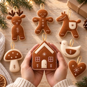 May include: A set of brown and cream felt ornaments featuring a gingerbread house, a reindeer, a gingerbread person, a horse, a mushroom, a bird, and a heart, each with white embroidered details and a small loop for hanging.