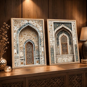 May include: Two rectangular framed wall art pieces featuring intricate architectural illustrations of arched doorways with ornate gold, blue, and white floral patterns and detailed lattice window designs, displayed side by side on a wooden surface.
