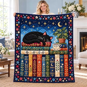 May include: A rectangular quilt featuring a black cat sleeping on a stack of colorful books. The design includes a night sky with stars and a crescent moon, a potted plant, and a steaming teacup. The border is decorated with small flowers.