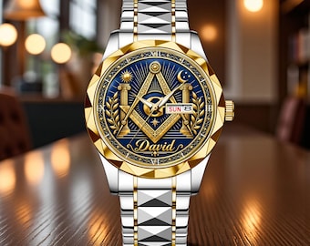 May include: A silver and gold-tone wristwatch with a blue dial featuring a gold Masonic square and compass emblem, the name David, a sun and moon motif, and a day-date window displaying SUN 8. The watch has a faceted gold bezel and a metallic link band.