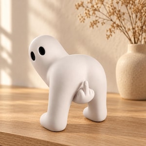 Peut inclure: Une figurine blanche mate et lisse en forme de fantôme avec deux yeux ovales noirs. Le fantôme est représenté dans une posture penchée, étendant une main depuis le bas de son dos pour montrer un doigt d'honneur dans une pose provocante.