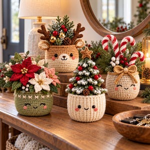 Könnte beinhalten: Vier gehäkelte Töpfe im Amigurumi-Stil mit lächelnden Gesichtern, die jeweils festliche Arrangements enthalten, darunter ein Weihnachtsstern, ein Rentier mit Geweih, ein geschmückter Weihnachtsbaum mit Stern und Zuckerstangen mit Schleife.