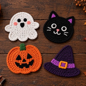 May include: Four crocheted coasters featuring Halloween designs: a white ghost with pink cheeks, a black cat with purple inner ears, an orange jack-o'-lantern with a green stem, and a purple witch hat with a yellow buckle and a purple band.