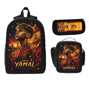 Könnte beinhalten: Ein schwarzer Rucksack, eine Lunchtasche und ein Federmäppchen mit einer Grafik von Lamine Yamal im rot-gelben Fußballtrikot. Der Text lautet Lamine Yamal, The Future of Spain und España, mit einer goldenen Pokalabbildung auf dem Mäppchen.