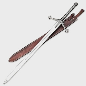 May include: A silver-coloured sword with a long, straight blade and a detailed, ornate crossguard featuring four-lobed ends. The handle is textured with intricate patterns, and the sword is accompanied by a brown leather scabbard with stitching.