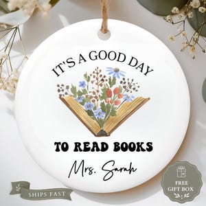 Round ornament with "It's a good day to read books Mrs. Sarah" and floral design.