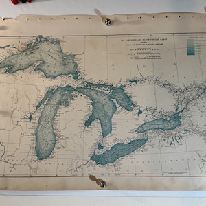 Könnte beinhalten: Eine antike Papierkarte mit dem Titel The Northern and Northwestern Lakes, die die Großen Seen in blauer Tinte auf cremefarbenem Hintergrund zeigt. Die Karte enthält detaillierte geografische Umrisse, Wassertiefen und regionale Beschriftungen.