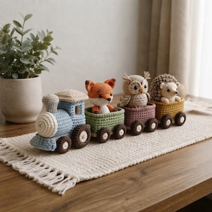 Puede incluir: Un conjunto de tren de juguete de ganchillo con una locomotora azul claro seguida de tres pequeños vagones. Cada vagón contiene un animal de peluche: un zorro naranja, un búho beige y un erizo marrón. El tren y los animales son de lana.