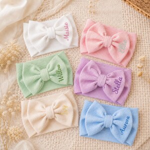 Può includere: Sei fasce per capelli in tessuto a coste con grandi fiocchi, ognuna con un nome ricamato. I colori includono bianco con Maisie, rosa con Ellie, verde chiaro con Willow, lavanda con Stella, crema con Ivy e azzurro con Aurora.