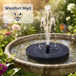 Puede incluir: Una fuente de agua solar redonda y negra que flota en un baño para pájaros de piedra, rociando un chorro de agua vertical. Un pequeño petirrojo con el pecho naranja se encuentra en el borde del cuenco. El texto Westfort Mart es visible.