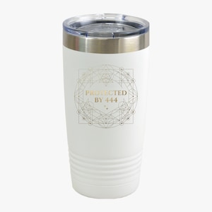 Könnte beinhalten: Ein weißer Edelstahlbecher mit transparentem Deckel und metallischem Rand. Auf der Vorderseite befindet sich ein goldenes, geometrisches, kreisförmiges Design, das den Text "PROTECTED BY 444" mit zwei kleinen vierzackigen Sternen umgibt.