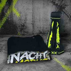 May include: A black t-shirt featuring the white and neon yellow text NACHT MODUS in a distressed font, paired with a black and neon yellow stand displaying the text NACHT MODUS and two X symbols on its base.