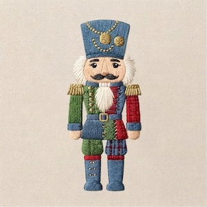 May include: An embroidered nutcracker patch featuring a blue hat with gold chain detail, white hair and beard, and a uniform with asymmetrical green, blue, and red panels. The design includes gold epaulets, a belt with a buckle, and blue boots.