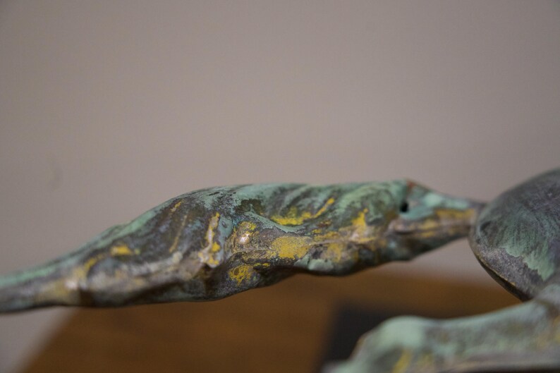 May include: Close-up of a green and yellow abstract sculpture with a textured surface.