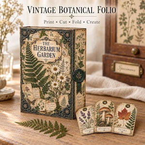 Puede incluir: Una caja rectangular titulada The Herbarium Garden con ilustraciones botánicas de helechos, margaritas y una mariposa. La caja presenta bordes oscuros ornamentados y un sello de cera. Se muestran tres etiquetas con lavanda, setas y una hoja de arce.