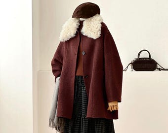 May include: A dark burgundy coat with a white faux fur collar, a brown beret, a brown sweater, a black and white checkered skirt, a grey scarf, and dark brown boots. A small black handbag is positioned on a ledge behind the mannequin.