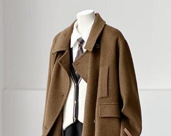 May include: A brown wool-blend coat with a notched collar and a single button closure, layered over a white collared shirt, a white cardigan with black trim, and a black skirt, all displayed on a mannequin against a plain white background.