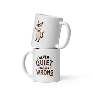 May include: Two white ceramic mugs stacked vertically. The top mug features a cartoon illustration of a standing Siamese cat. The bottom mug displays the text "NEVER QUIET, RARELY WRONG" in bold, dark brown lettering with decorative accents.