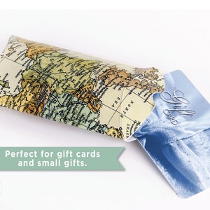 May include: A brown and beige paper gift card holder with a world map design. The holder is open and a blue gift card with the text "Gift Card" is partially visible.