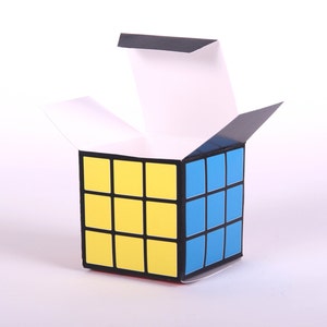 May include: An open box with a black and white checkered pattern on the outside. The box is made of cardboard and has a yellow and blue design on the inside.