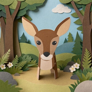 Peut inclure: Une figurine de cerf en papier se tient dans une scène de forêt en papier superposé. Le cerf est marron avec un museau crème et de grandes oreilles. L'arrière-plan présente des arbres verts, des collines, un nuage blanc et des fleurs blanches.