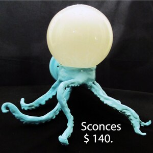 May include: A pair of blue ceramic wall sconces shaped like an octopus with a white globe light fixture. Sconces $140.