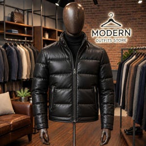 Puede incluir: Una chaqueta acolchada de cuero negro con cuello alto, cremallera frontal completa y dos bolsillos laterales con cremallera. La chaqueta se exhibe en un maniquí con un suéter de cuello alto negro en una tienda de ropa.