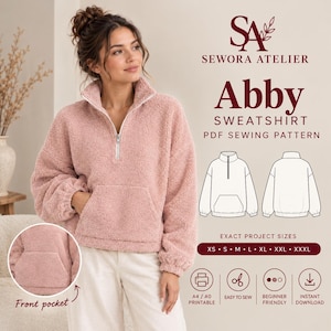 Puede incluir: Una sudadera de forro polar rosa polvoriento con cierre de cremallera de un cuarto, mangas largas y un bolsillo canguro frontal. El texto dice SEWORA ATELIER, Abby SWEATSHIRT PDF SEWING PATTERN, EXACT PROJECT SIZES XS S M L XL XXL XXXL, A4 A0 PRINTABLE, EASY TO SEW, BEGINNER FRIENDLY, INSTANT DOWNLOAD.