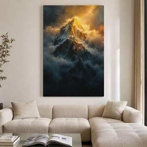 Peut inclure: Une impression d'art mural verticale représentant un sommet de montagne enneigé illuminé par une lumière dorée. La montagne est entourée de nuages sombres et denses et d'ombres profondes, créant une scène contrastée de tons or, blanc et noir.