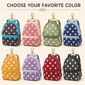 May include: Eight miniature backpack keychains with polka dot patterns in various colors including brown, pink, green, blue, yellow, purple, red, and black. Each bag features a gold-tone metal lobster clasp, a front zipper pocket, and shoulder straps.