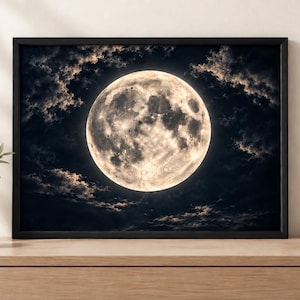 May include: A framed wall art print featuring a detailed, luminous full moon centered against a dark, cloudy night sky. The moon displays visible craters and textured surface details in shades of cream and white, contrasted by deep black clouds.