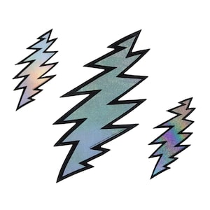 May include: Three iridescent glitter lightning bolt stickers. The stickers are black outlined and have a holographic finish.