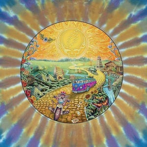 May include: A colorful graphic tee featuring a circular design with a yellow sun and a skull. A road winds through a landscape with a bus, motorcycle, and buildings. The background has a tie-dye pattern in shades of orange, yellow, and blue.