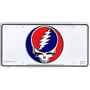 May include: A white license plate with a colorful Steal Your Face logo. The logo features a red and blue circle with a white lightning bolt and skull design. The plate has a white border and the text "NOT FOR OFFICIAL USE".