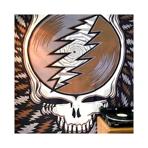 May include: A tapestry featuring a brown and white skull with a swirling, psychedelic design. The skull is surrounded by a black and white lightning bolt pattern.