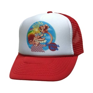 May include: White trucker hat with a red mesh back. The front of the hat features a colorful graphic of a cartoon character with the text "Grateful Dead" in a red circle.