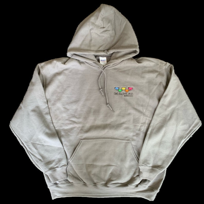 Puede incluir: Una sudadera con capucha gris con un bolsillo en la parte delantera. La sudadera tiene un logotipo bordado de cinco osos coloridos con el texto "The Button Bear" y "Chicago, IL".