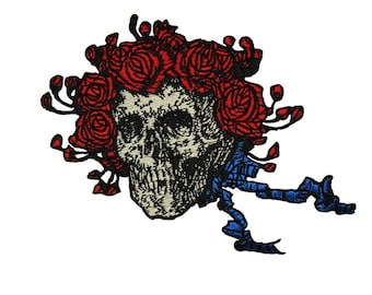 May include: An embroidered patch featuring a skull with red roses and a blue ribbon. The skull is surrounded by red roses and has a blue ribbon tied around it.