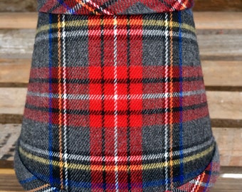 May include: A gray, red, white, and blue plaid lampshade with a folded edge.