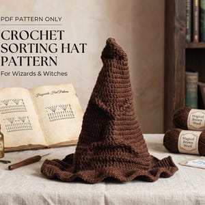 May include: A brown crocheted sorting hat with a pointed, folded top and a wide, wavy brim. Beside it lies an open book titled Hogwarts Hat Pattern, a small gold bottle labeled Felix Felicis, a crochet hook, and two skeins of brown yarn.