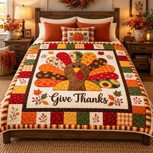 Può includere: Una trapunta a tema Ringraziamento con un tacchino centrale dalle piume colorate e decorate e la scritta Give Thanks. La trapunta presenta un bordo patchwork composto da quadrati arancioni, rossi, verdi e gialli con motivi a foglie.