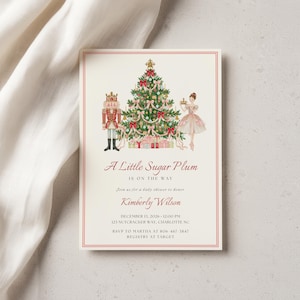 May include: A rectangular baby shower invitation card featuring a watercolor illustration of a Christmas tree, a nutcracker, and a ballerina. The text reads A Little Sugar Plum IS ON THE WAY, join us for a baby shower to honor Kimberly Wilson, December 13, 2026, 12:00 PM, 123 Nutcracker Way, Charlotte NC, RSVP to Martha at 806-467-3847, Registry at Target.