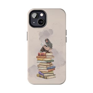 Puede incluir: Una funda de smartphone beige con una ilustración estilo acuarela de una persona con cabello largo y oscuro y auriculares rojos sentada sobre una alta pila de libros coloridos. El diseño incluye suaves acentos grises como nubes.