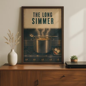 Può includere: Una stampa artistica incorniciata intitolata THE LONG SIMMER che raffigura una grande pentola di metallo su un fornello con vapore che sale dal contenuto. Un mestolo poggia sulla pentola e un piccolo vassoio di verdure si trova sul fornello.