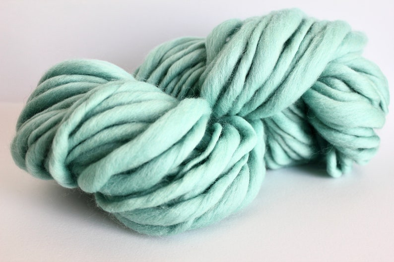 May include: A large skein of soft, light green yarn. The yarn is thick and fluffy, perfect for knitting or crocheting.