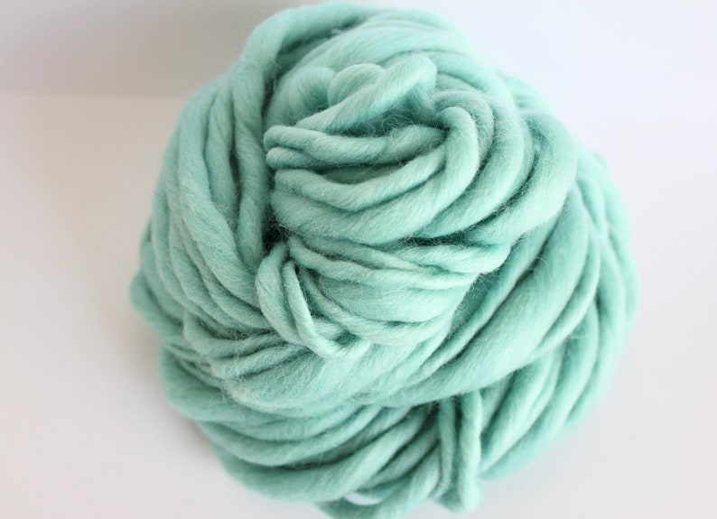 May include: A ball of soft, light blue yarn. The yarn is made of wool and is perfect for knitting or crocheting.