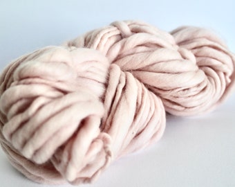 May include: A large skein of soft, pale pink yarn. The yarn is thick and fluffy, perfect for knitting or crocheting.