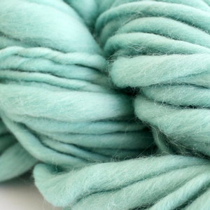 May include: A close-up of a skein of soft, light blue yarn. The yarn is made of wool and is perfect for knitting or crocheting.