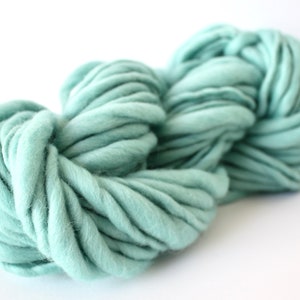 May include: A skein of soft, light blue yarn. The yarn is thick and fluffy, perfect for knitting or crocheting.