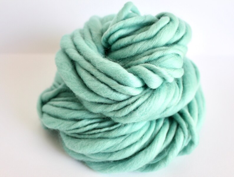 May include: A large skein of soft, light green yarn. The yarn is made of wool and is perfect for knitting or crocheting.